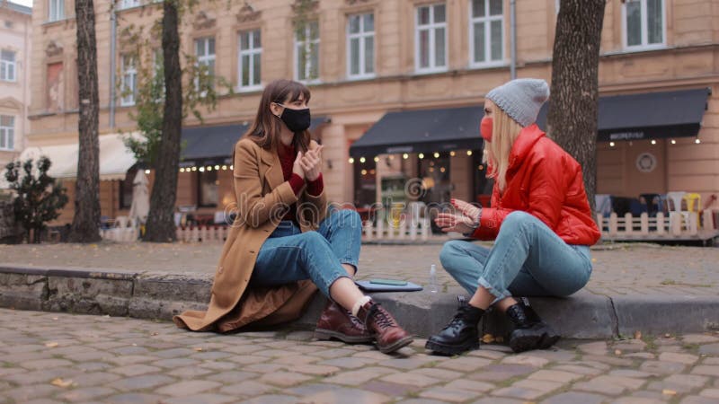 Kvinnor i medicinska masker som chattar på gatan stock video