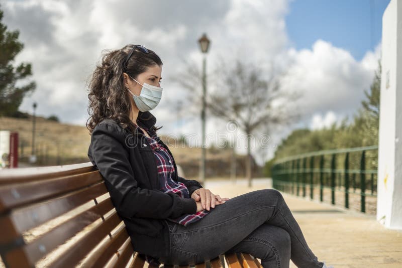 Kvinnor med en antikovid 19 masker som sitter i en park royaltyfri fotografi