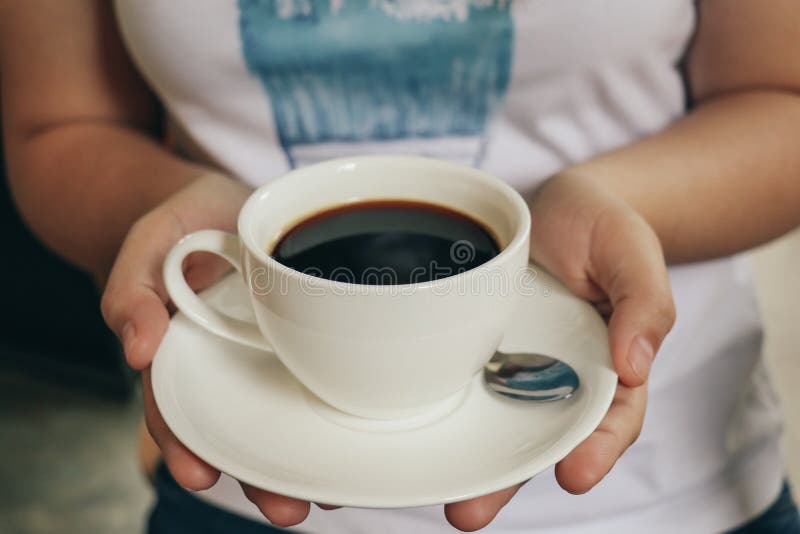 Kvinnor rymmer en kopp av svart kaffe Inte gör de ser smaskiga arkivbilder