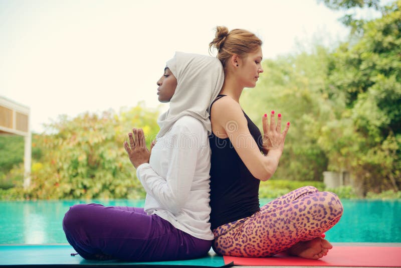 Kvinnor som gör yoga vid poolsiden royaltyfri foto Kvinnor som gör yoga vid poolsiden royaltyfri foto