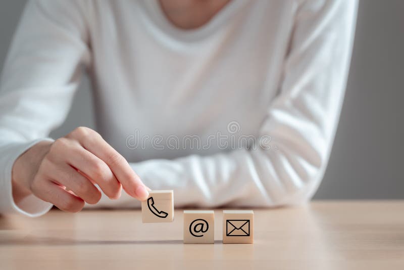 Kvinnor som håller träblock med ikone-post och e-post kontaktar oss anslutning till affärskommunikation online royaltyfri foto