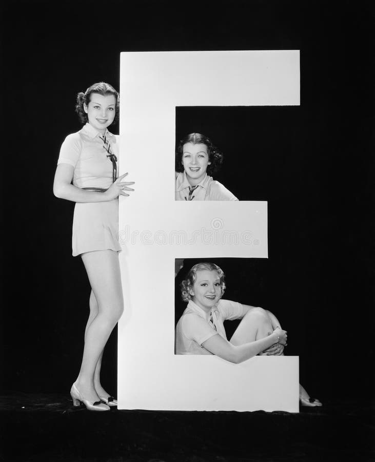 Women posing with huge letter E (All persons depicted are no longer living and no estate exists. Supplier grants that there will be no model release issues.). Women posing with huge letter E (All persons depicted are no longer living and no estate exists. Supplier grants that there will be no model release issues.)