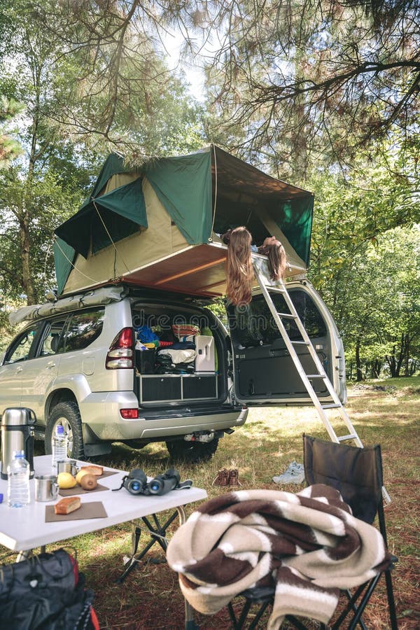 Kvinnor som vilar att ligga i tält över bilen och att se naturen royaltyfri foto Kvinnor som vilar att ligga i tält över bilen och att se naturen royaltyfri foto