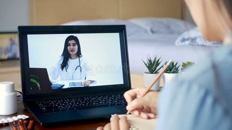 Kvinnor som är sjuka använder en videokonferens gör onlinekonsultation med läkare på en bärbar datorpatient och fråga läkare om sj
