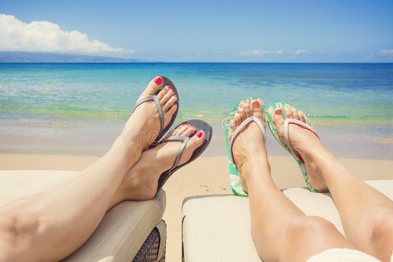 Kvinnor som är slö och solbadar på en idyllisk strand