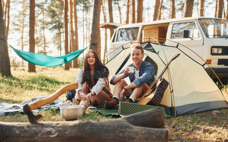 Kvällstid. Unga par reser tillsammans i skogen royaltyfri bild