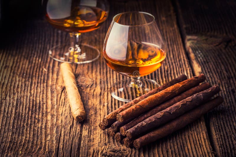 quality cigars and cognac on an old wooden table. quality cigars and cognac on an old wooden table