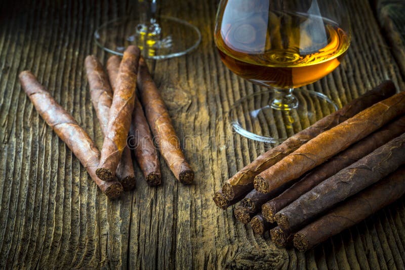 quality cigars and cognac on an old wooden table. quality cigars and cognac on an old wooden table