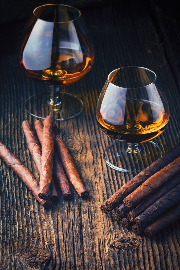 quality cigars and cognac on an old wooden table. quality cigars and cognac on an old wooden table