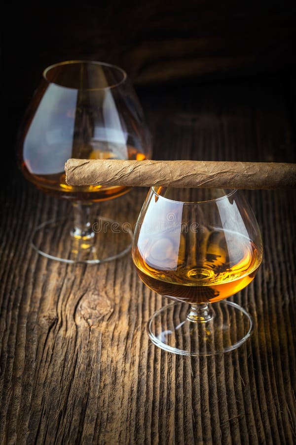 quality cigars and cognac on an old wooden table. quality cigars and cognac on an old wooden table