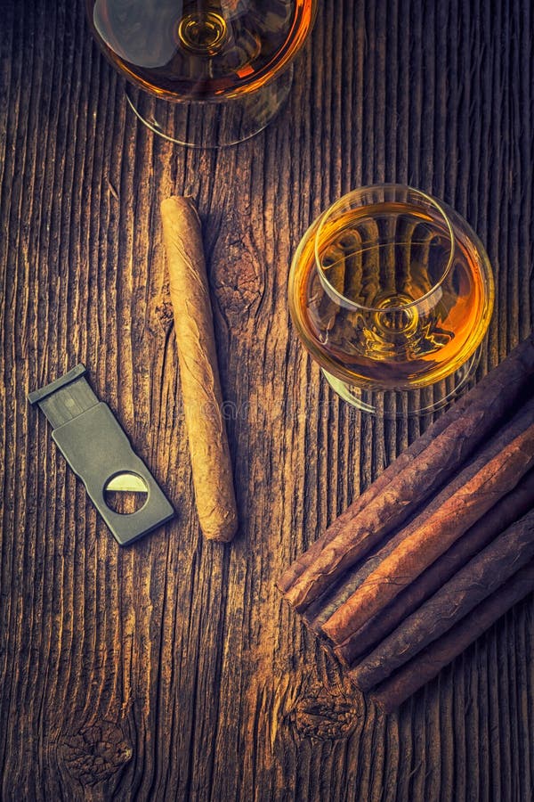 quality cigars and cognac on an old wooden table. quality cigars and cognac on an old wooden table
