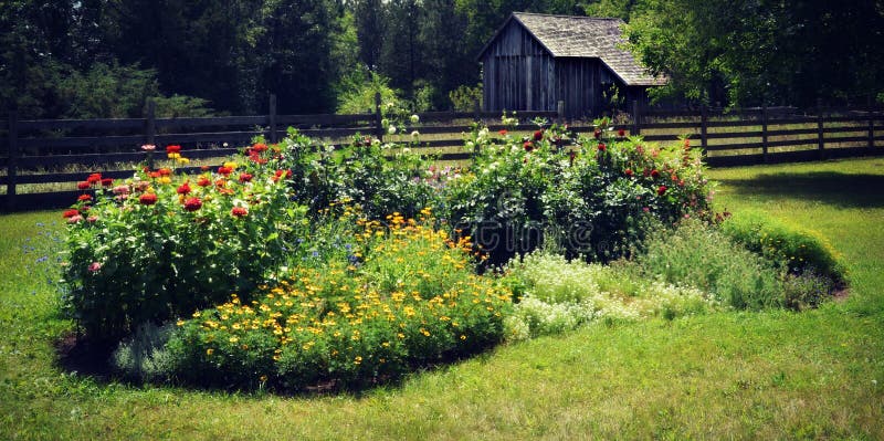A flower garden with an outbuilding behind the fence at Old World Wisconsin in Eagle, WI. A flower garden with an outbuilding behind the fence at Old World Wisconsin in Eagle, WI.