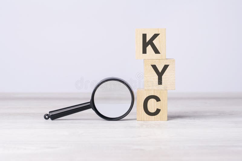 Concept know your customer or KYC. Text on wooden cubes under a magnifying glass. stock photography