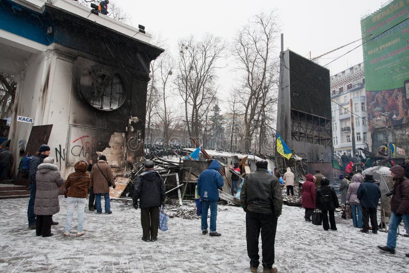 KYIV, UCRAINA: Il supporto della gente vicino alle barriere nasconde le squadre della polizia dietro sulla via d'occupazione della immagine stock libera da diritti