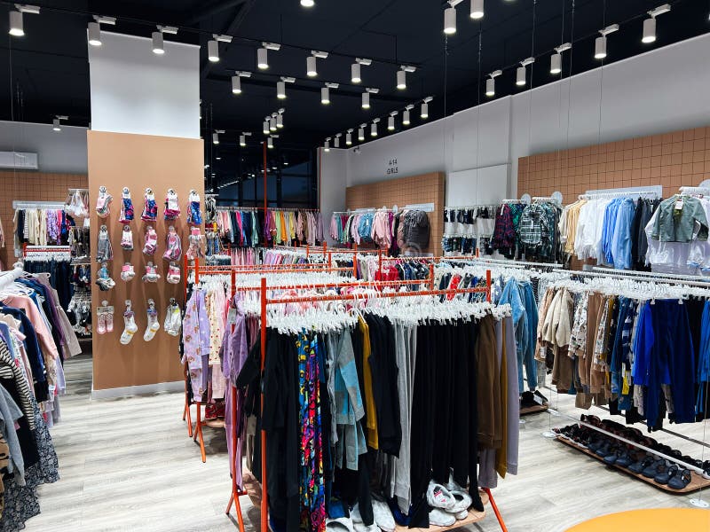 Kyiv ucrania enero 04 2025 : interior de una tienda de ropa luminosa con racks de ropa organizados foto de archivo libre de regalías