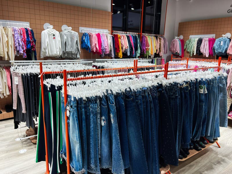 Kyiv ucrania enero 04 2025 : tienda de ropa moderna de interiores lustrando jeans y blusas coloridas en las vitrinas imagen de archivo libre de regalías