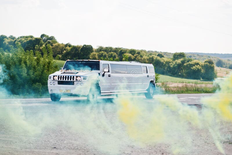 Kyiv, Ukraine - August 31: Elegance white wedding limousine Hummer H2 ride background colour smoke from smokes bomb at wedding da