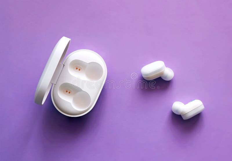 White earbuds MI True Wireless by Xiomi with built-in microphones for hands-free communication on purple background