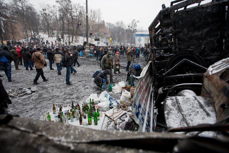 KYIV, УКРАИНА - 21-ОЕ ЯНВАРЯ: Протестующие подготавливают коктейль Молотоваа с бензином на баррикадах и ждут бои с полицией стоковое фото KYIV, УКРАИНА - 21-ОЕ ЯНВАРЯ: Протестующие подготавливают коктейль Молотоваа с бензином на баррикадах и ждут бои с полицией стоковое фото