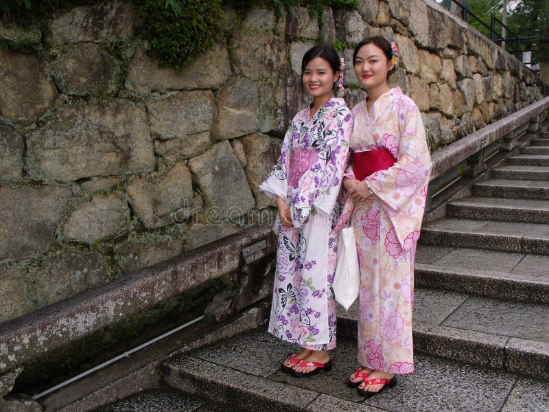 Two girls dressed in the traditional colored kimono on the staircase of a Kyoto temple stock photography