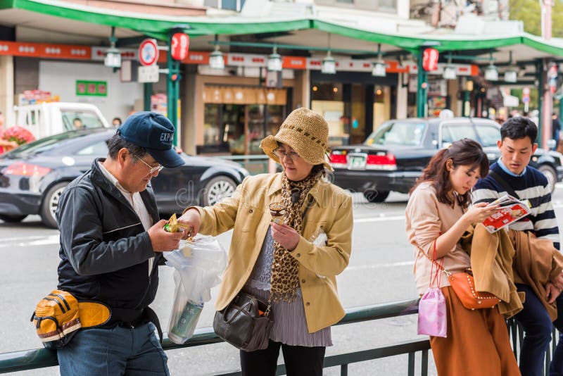 KYOTO, JAPÃO - 7 DE NOVEMBRO DE 2017: Pares de turistas em uma rua da cidade Close-up imagens de stock KYOTO, JAPÃO - 7 DE NOVEMBRO DE 2017: Pares de turistas em uma rua da cidade Close-up imagens de stock