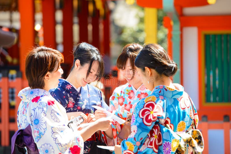 Kyoto, Japón - 28 de marzo de 2015: Mujer japonesa en kimono que lee tiras de la predicción de la fortuna de O-mikuji de papel en foto de archivo libre de regalías Kyoto, Japón - 28 de marzo de 2015: Mujer japonesa en kimono que lee tiras de la predicción de la fortuna de O-mikuji de papel en foto de archivo libre de regalías