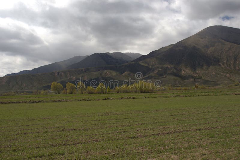 Kyrgyzstan& x27;s mountain view from Grigorievka village near Issyk-Kul lake in May royalty free stock photos Kyrgyzstan& x27;s mountain view from Grigorievka village near Issyk-Kul lake in May royalty free stock photos