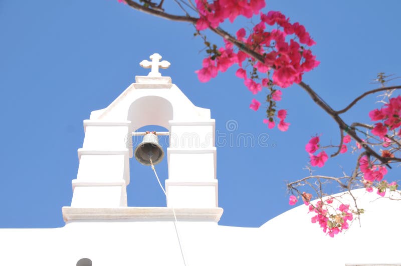 Kyrkliga Klocka och rosa färgblommor i Mykonos, Grekland royaltyfria foton Kyrkliga Klocka och rosa färgblommor i Mykonos, Grekland royaltyfria foton