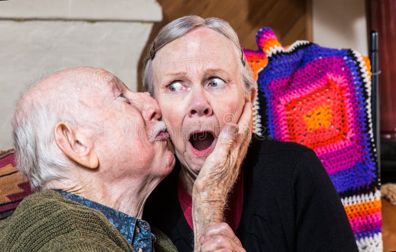 Kyssande äldre kvinna för äldre gentleman på kind arkivfoto Kyssande äldre kvinna för äldre gentleman på kind arkivfoto
