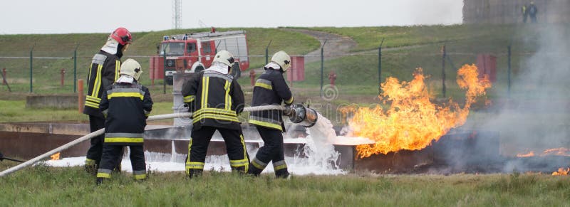 Kämpfendes Feuer mit einem Schaumfeuerlöscher lizenzfreie stockbilder Kämpfendes Feuer mit einem Schaumfeuerlöscher lizenzfreie stockbilder