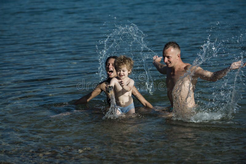 Kärlek och förtroende som familjevärden Mor och far med son som simmar till havs på stranden Familjeresor med barn på mödrar elle royaltyfria bilder
