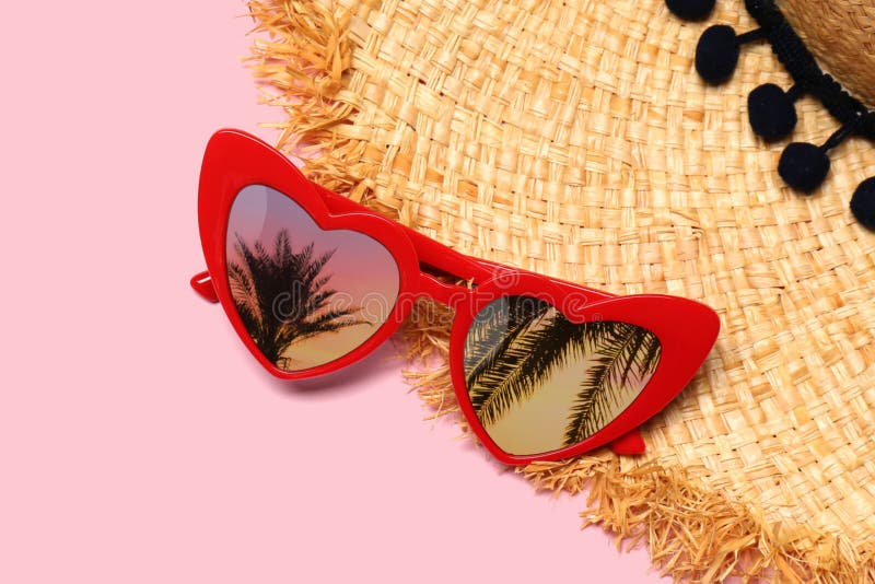 Kärnformade solglasögon med reflektion av palmträd på rosa bakgrund