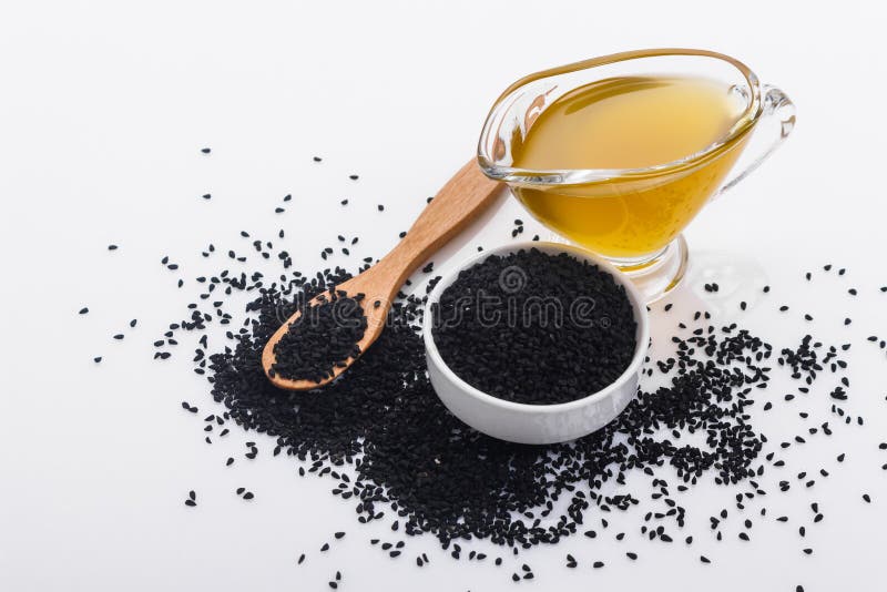 Körner des Schwarzkümmels und des Öls auf dem rustikalen Hintergrund lizenzfreie stockbilder