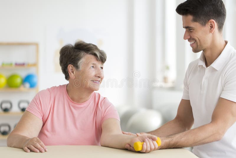 Körperlicher Therapeut, der seinen Bezirk stützt lizenzfreies stockfoto Körperlicher Therapeut, der seinen Bezirk stützt lizenzfreies stockfoto