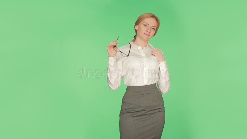 Körpersprache Schönes blondes Mädchen in einer weißen Bluse auf einem grünen Hintergrund