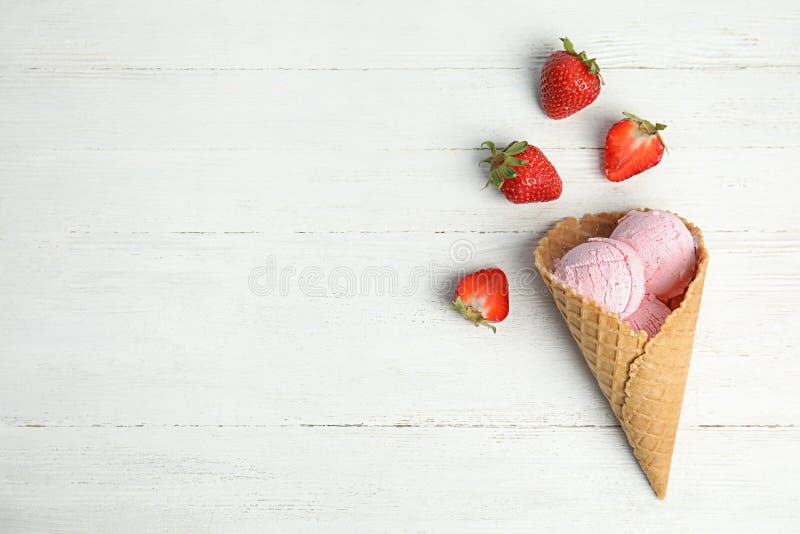 Köstliche Eiscreme im Waffelkegel und Erdbeeren auf Holztisch stockfoto Köstliche Eiscreme im Waffelkegel und Erdbeeren auf Holztisch stockfoto