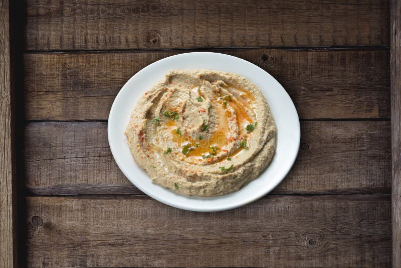 Köstlicher Hummus auf rustikalen Küchentisch aus Holz stockbild