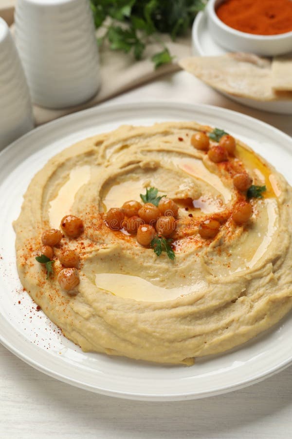 Köstlicher Hummus mit Oliven-Kichererbsen und Paprika auf weißem Holztisch geschlossen lizenzfreies stockbild