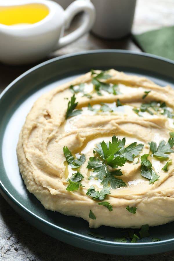 Köstlicher Hummus mit Olivenöl und Petersilie am Tisch geschlossen stockbilder