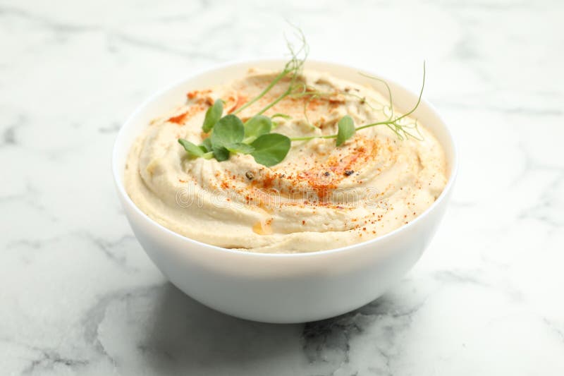 Köstlicher Hummus mit Paprika in Schüssel auf weißem Marmortisch geschlossen stockfotos