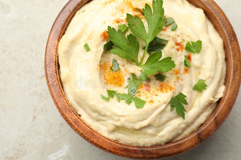 Köstlicher Hummus mit Paprika und Petersilie in Schüssel auf grauem Hintergrund Oberansicht lizenzfreies stockbild
