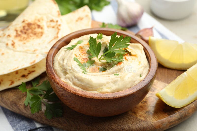 Köstlicher Hummus mit Petersilie Paprika Pita und Zitrone am Tisch geschlossen stockbild