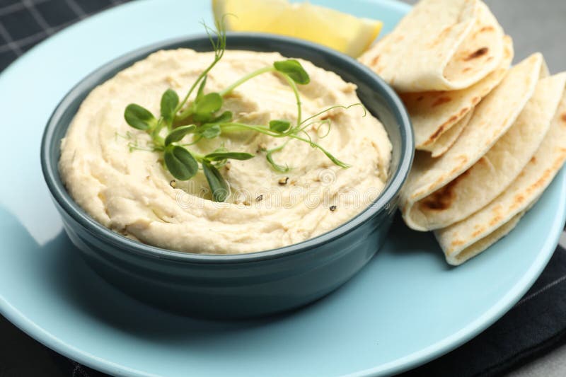 Köstlicher Hummus in Schüssel Pita und Zitrone am Tisch geschlossen lizenzfreie stockfotos