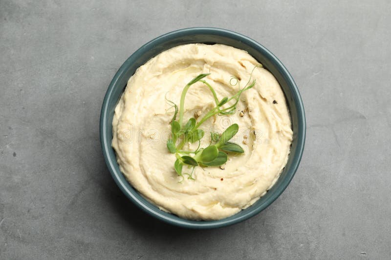 Köstlicher Hummus in Schüssel und Pita auf grauem Tischspiegel stockfoto