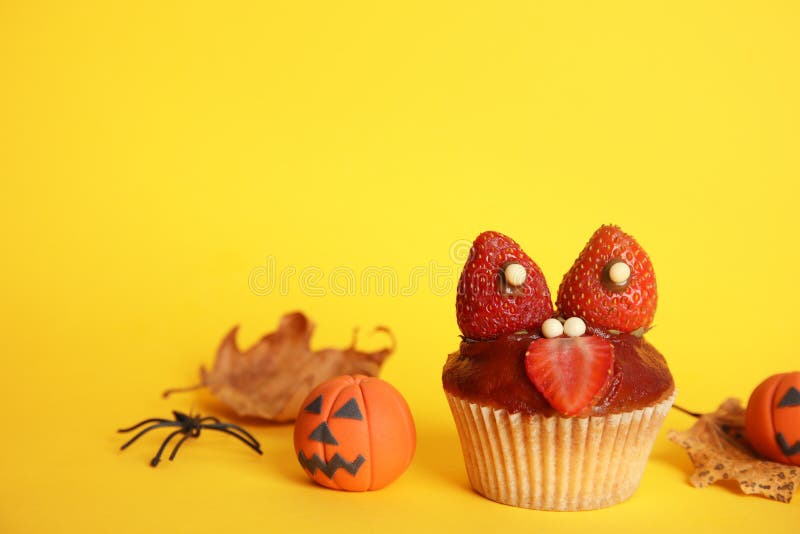 Köstlicher weniger Kuchen dekoriert als Monster auf gelbem Hintergrund. Halloween-Festlichkeit stockfotografie