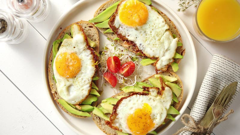 Köstliches gesundes Frühstück mit geschnittenen Avocadosandwichen mit Spiegelei
