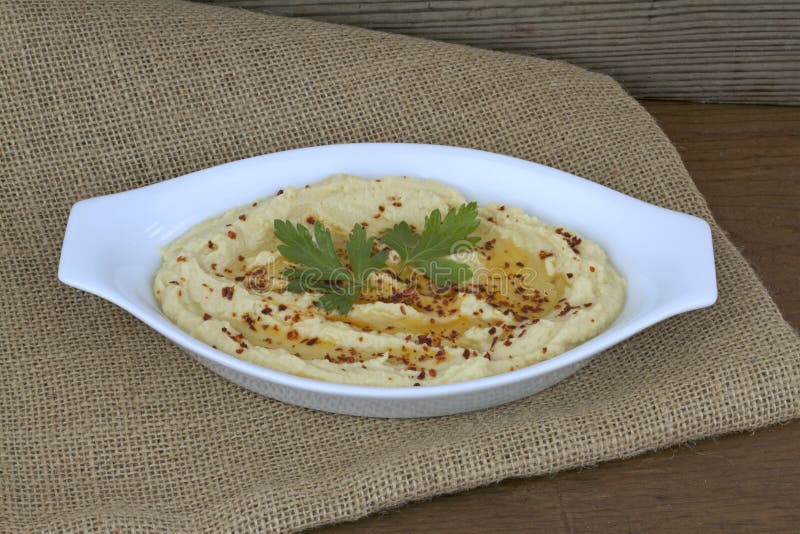 Köstliches hummus in der weißen Platte auf Leinwand stockbild