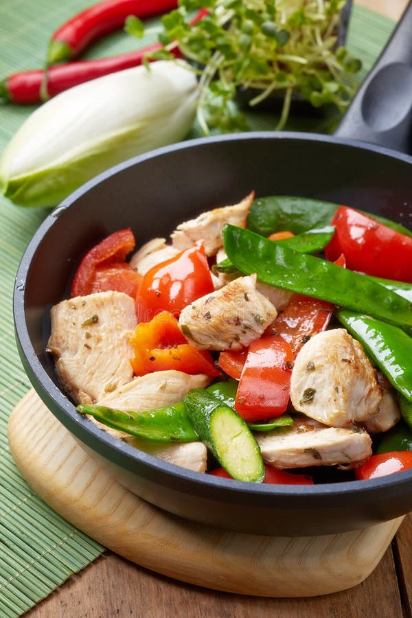 Kött och grönsaker för fegt bröst på stekpannan arkivfoton Kött och grönsaker för fegt bröst på stekpannan arkivfoton