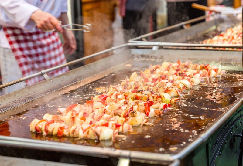 Kött och grönsaker på träpinnar som steker i kokande olja på mässan Gatamat royaltyfria bilder Kött och grönsaker på träpinnar som steker i kokande olja på mässan Gatamat royaltyfria bilder