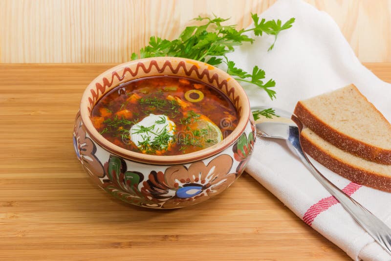 Kött solyanka i bunke, sked och bröd på trätabellen arkivbild Kött solyanka i bunke, sked och bröd på trätabellen arkivbild